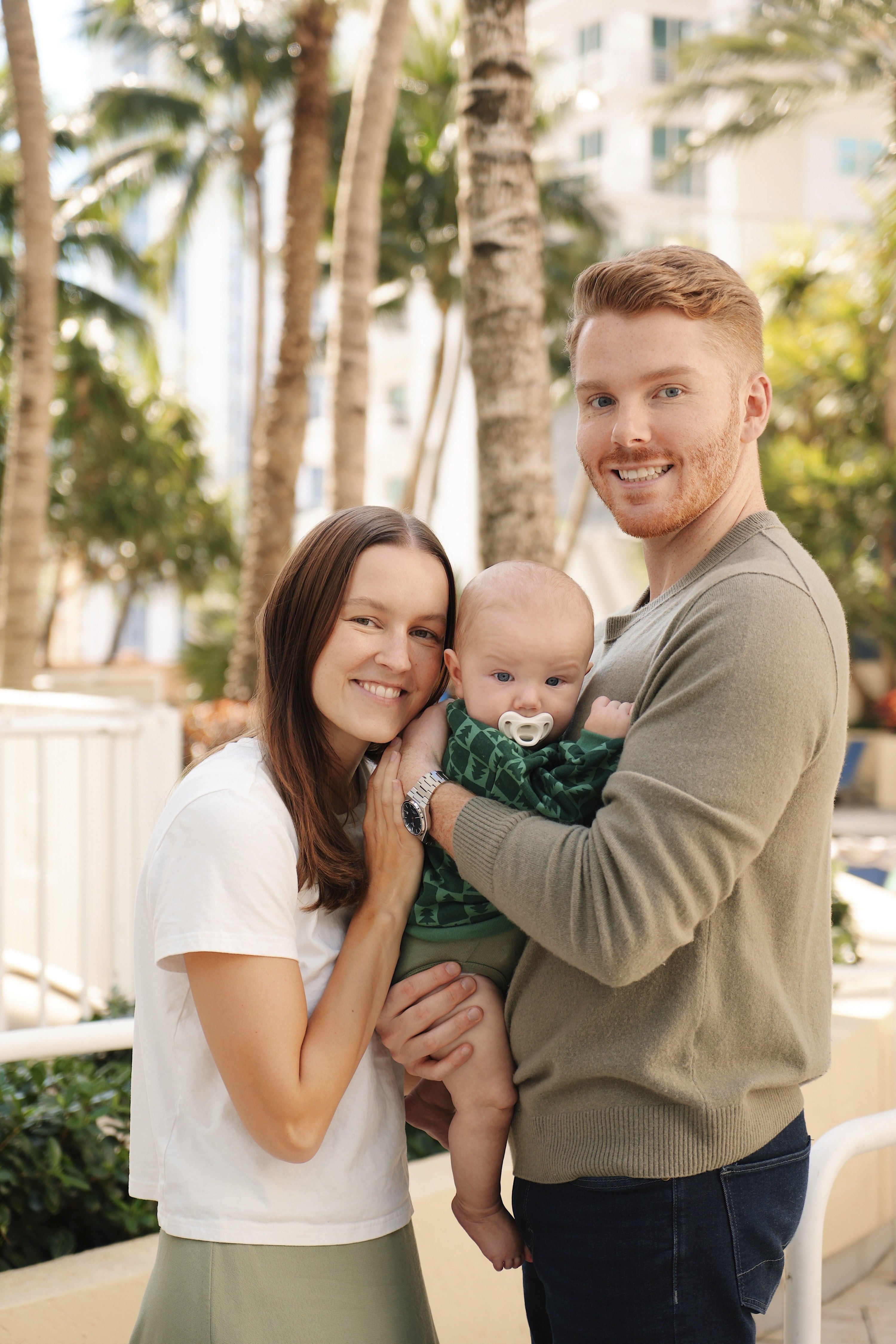 Father holding newborn with his wife in Miami