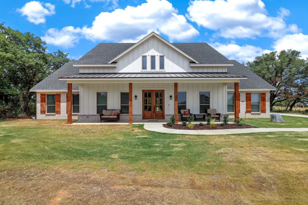 farmhouse with wood columns and large front porch with attic space