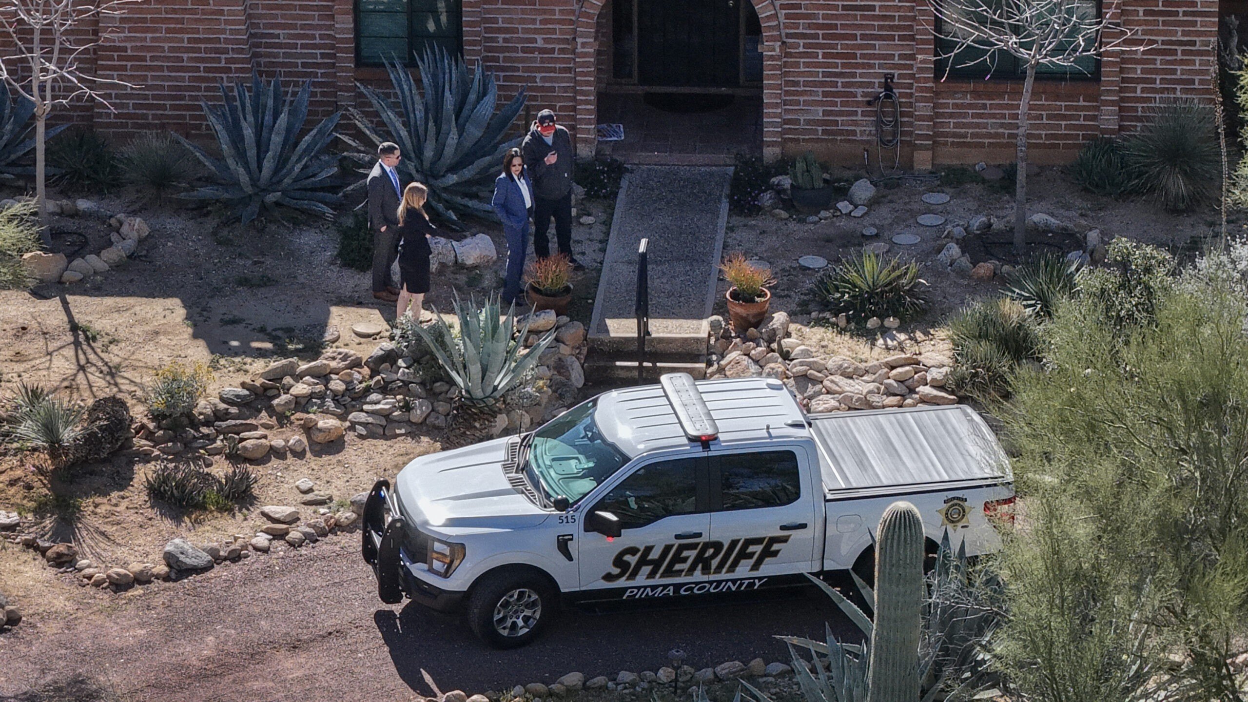 In an aerial view, law enforcement officials visit the backyard of Nancy Guthrie's residence