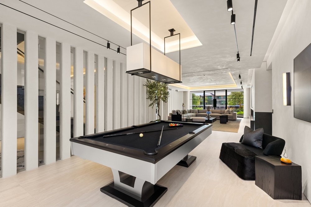 Modern Game Room with Black Billiard Table, Lounge Area, and Track Lighting