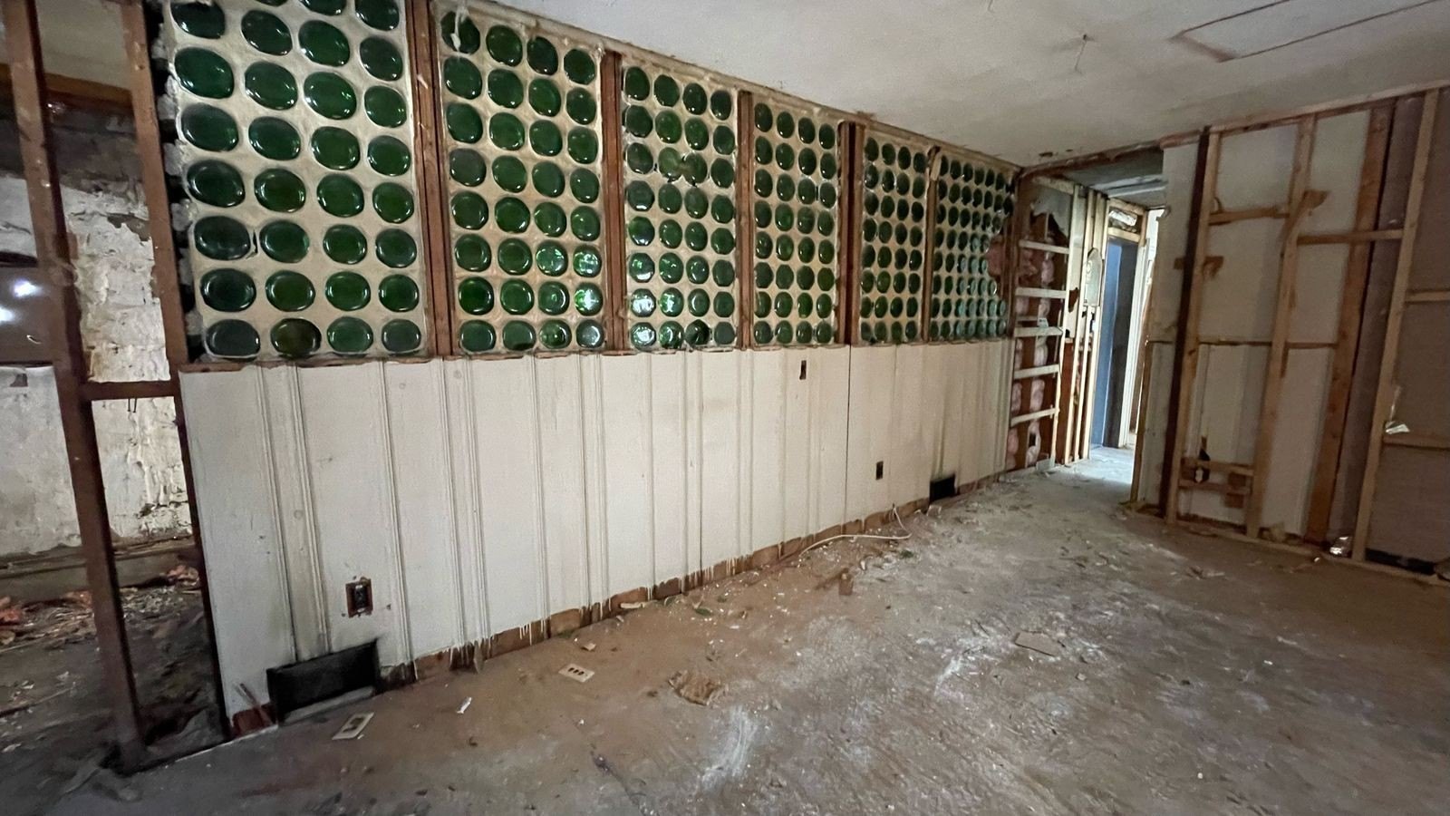 By the time Schiller peeled off the layers and got down to the prune juice bottles, the wall in danger of crumbling and bringing the roof down, so it had to be taken down.