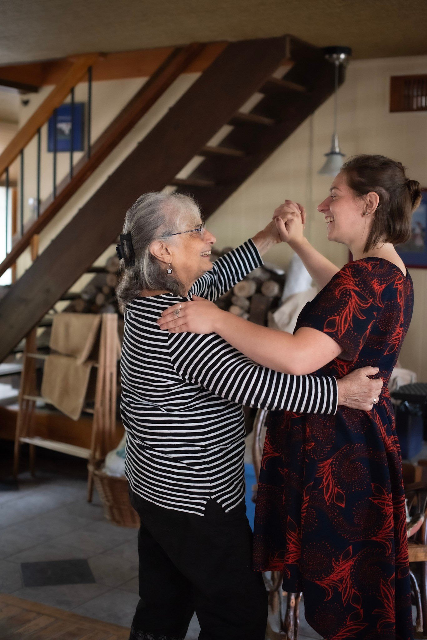 An older woman dances with her younger house guest