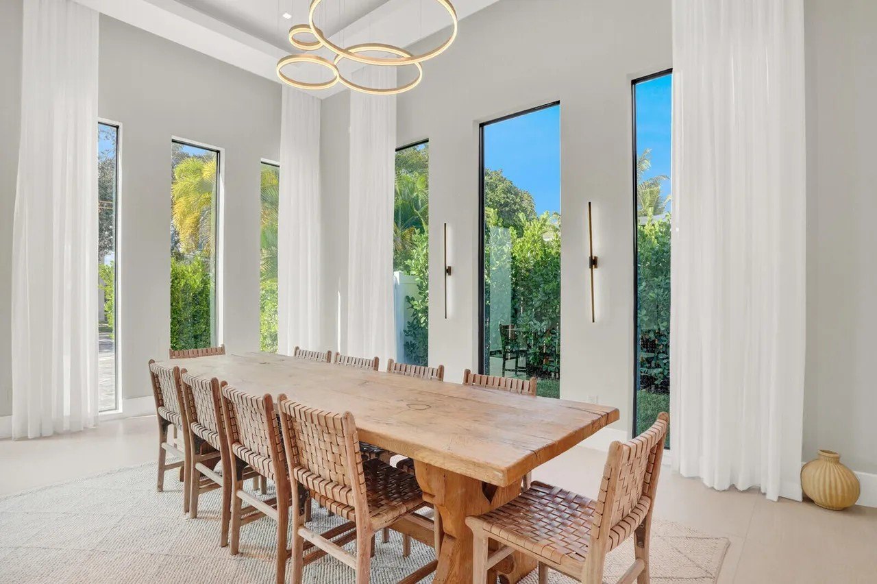 Dining area with large wooden table in Tommy Paul Florida home
