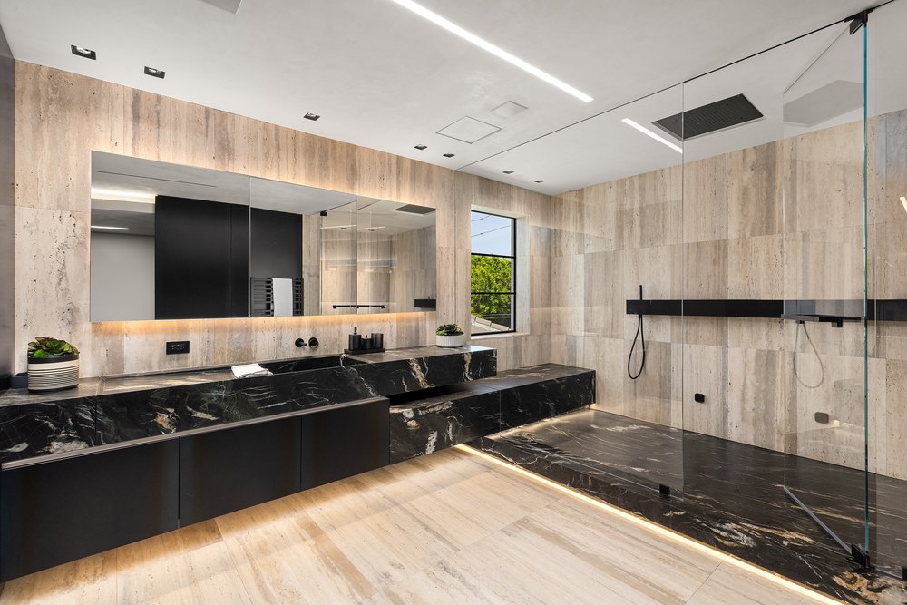Modern Bathroom with Black Marble Vanity, Walk-In Shower, and Travertine Tiles