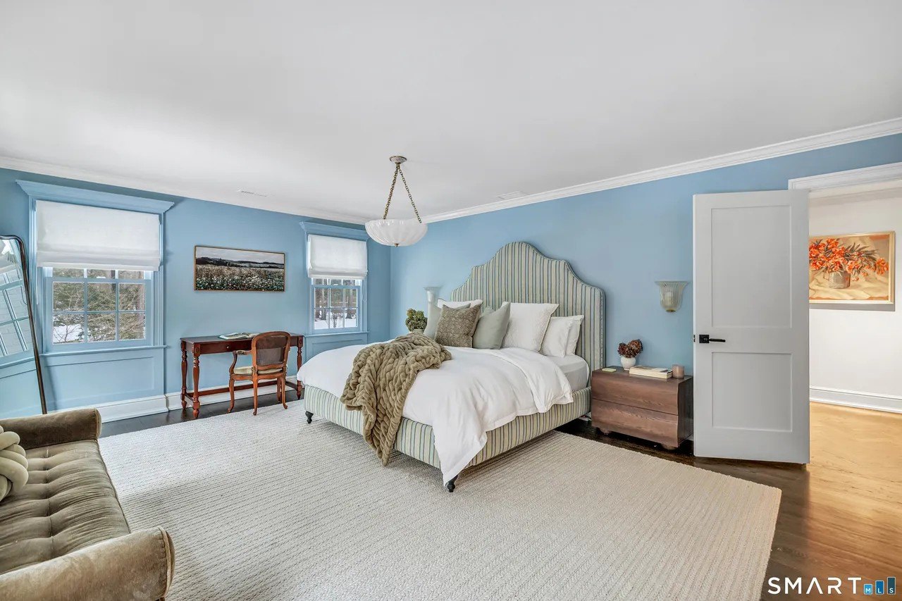 A bedroom with powder blue walls in Paige Lorenze Connecticut home