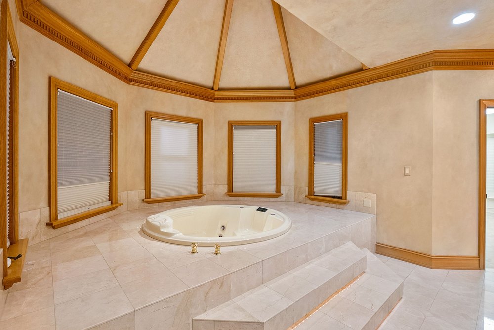 Primary Bathroom Suite with Raised Soaking Tub, Tile Surround, and Vaulted Ceiling
