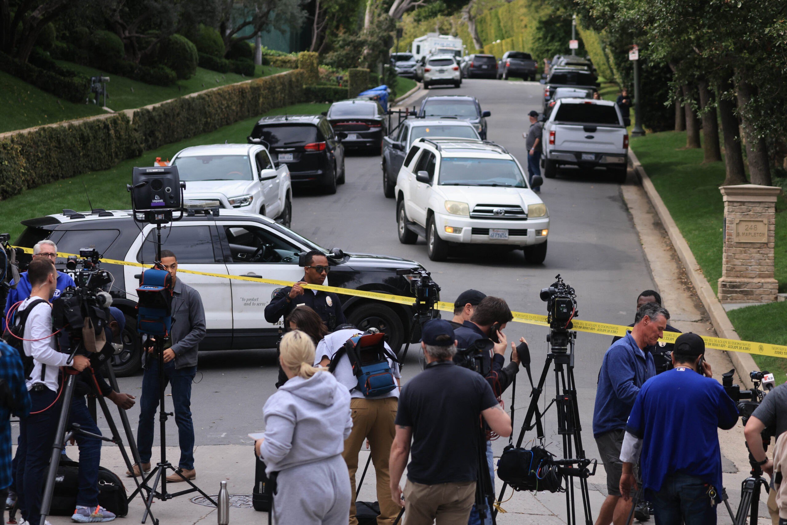 Police and members of the media gather outside the home of US producer and musician Sean "Diddy" Combs in Los Angeles on March 25, 2024. Homes belonging to Sean "Diddy" Combs were being raided by federal agents, media reported on March 25, with the US hip hop mogul at the center of sex trafficking and sex assault lawsuits. (Photo by David SWANSON / AFP) (Photo by DAVID SWANSON/AFP via Getty Images)