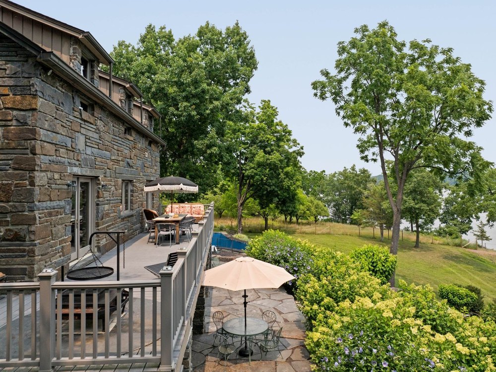 Waterfront decks of Four Mile River House in Athens, NY, on sale for $2,450,000