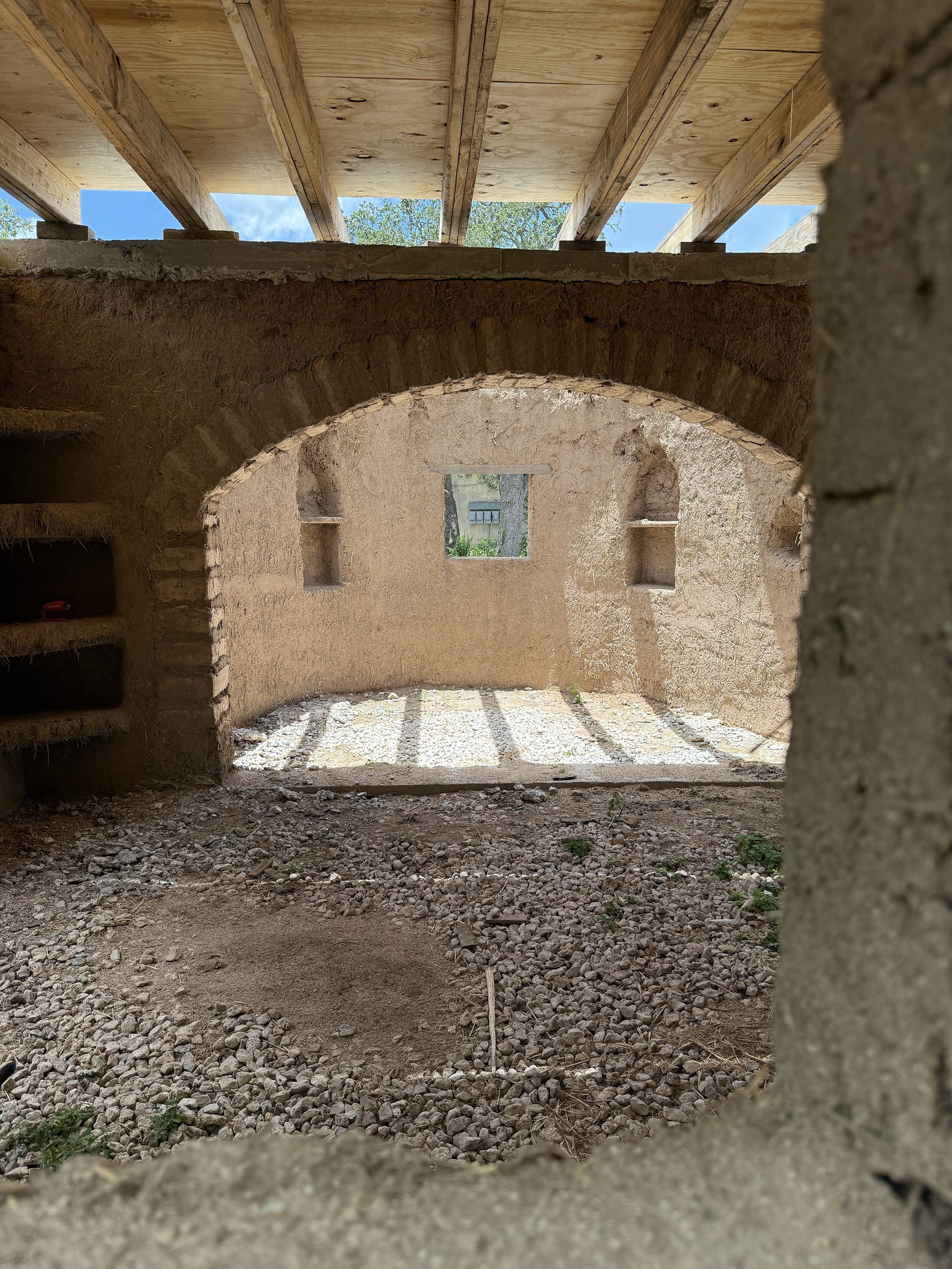 Raw Earthen Wall Interior and Arched Entryway Framing