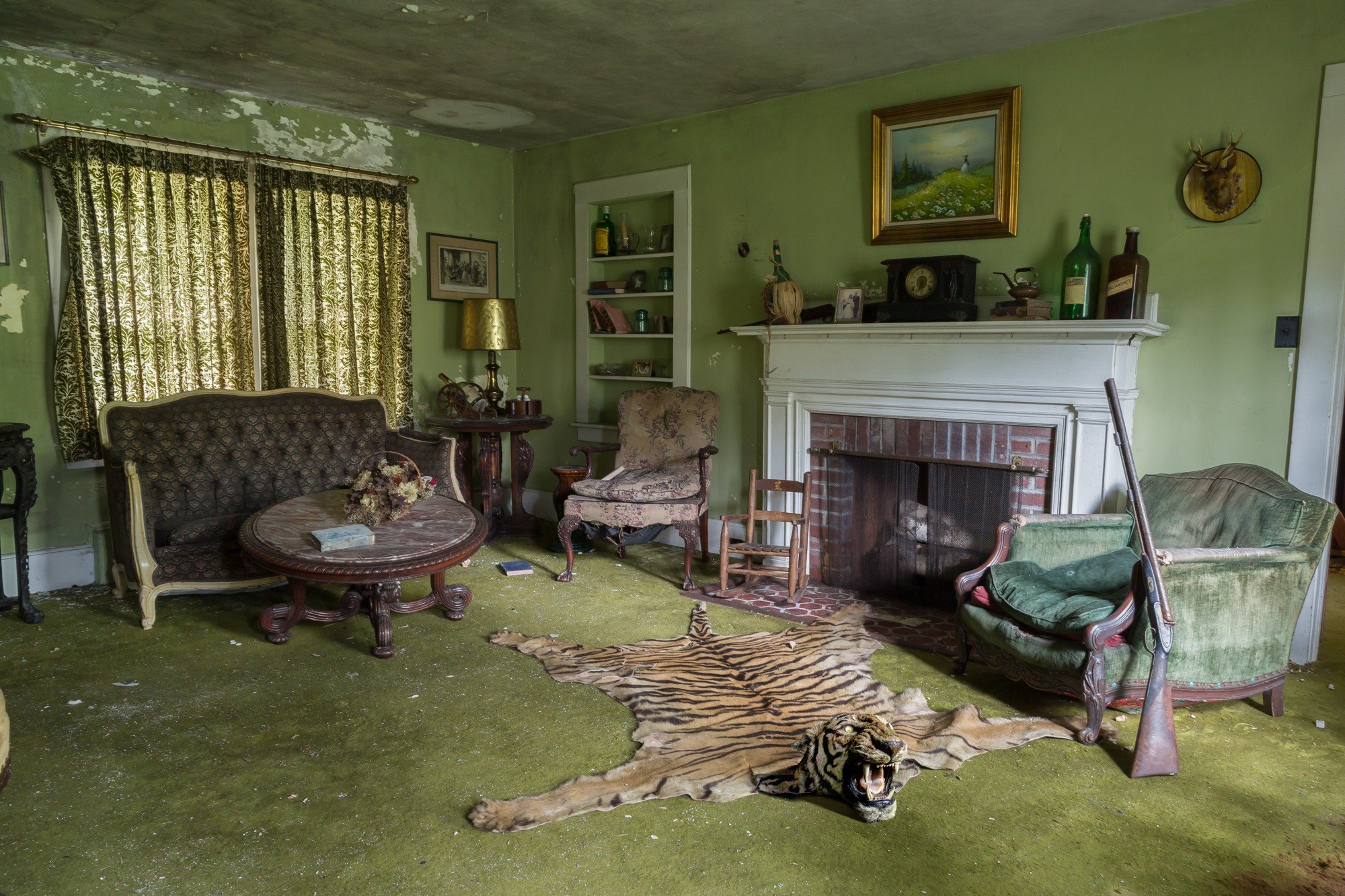 An abandoned home in The Catskills in New York with a tiger rug on the floor and a gun