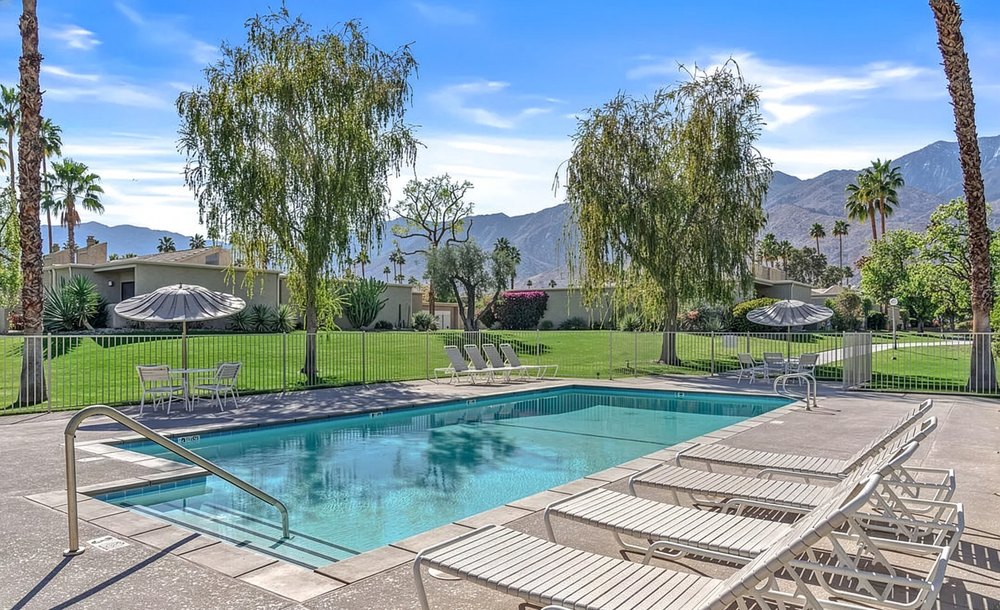 Swimming pool with lounge chairs and mountain backdrop