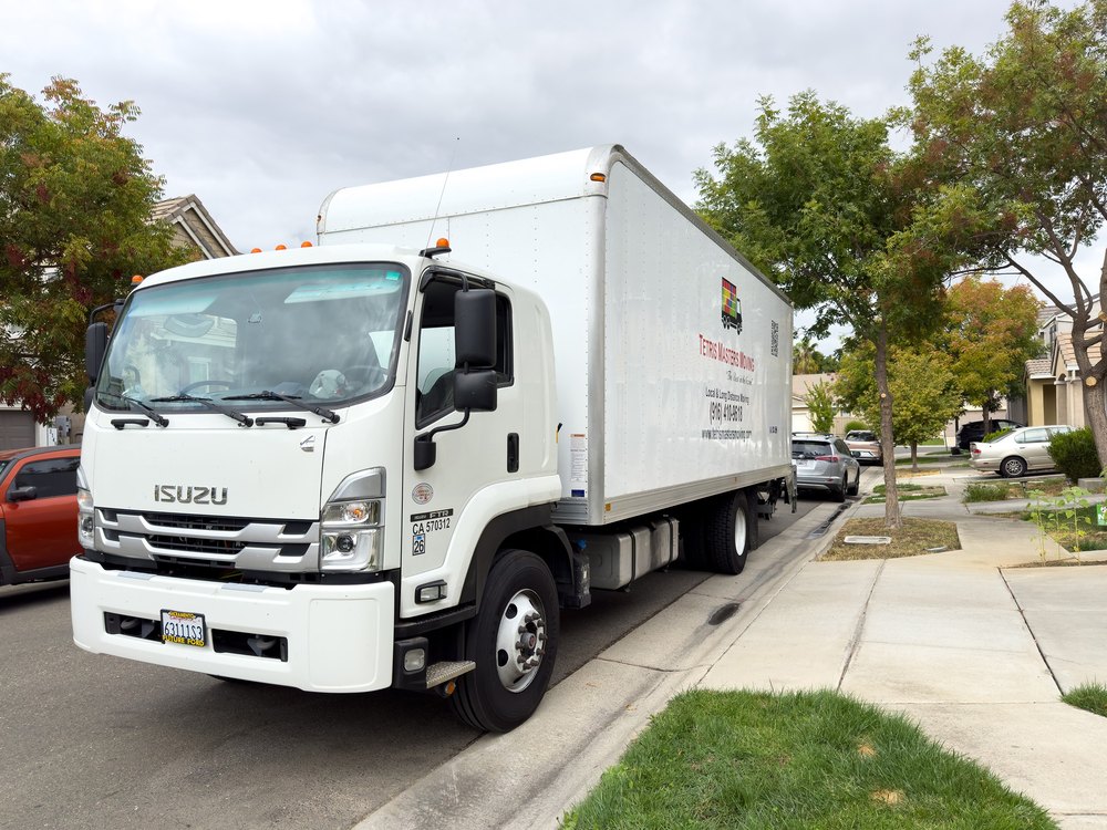 Editorial use only - Isuzu moving box truck parked by a house. Relocating day.