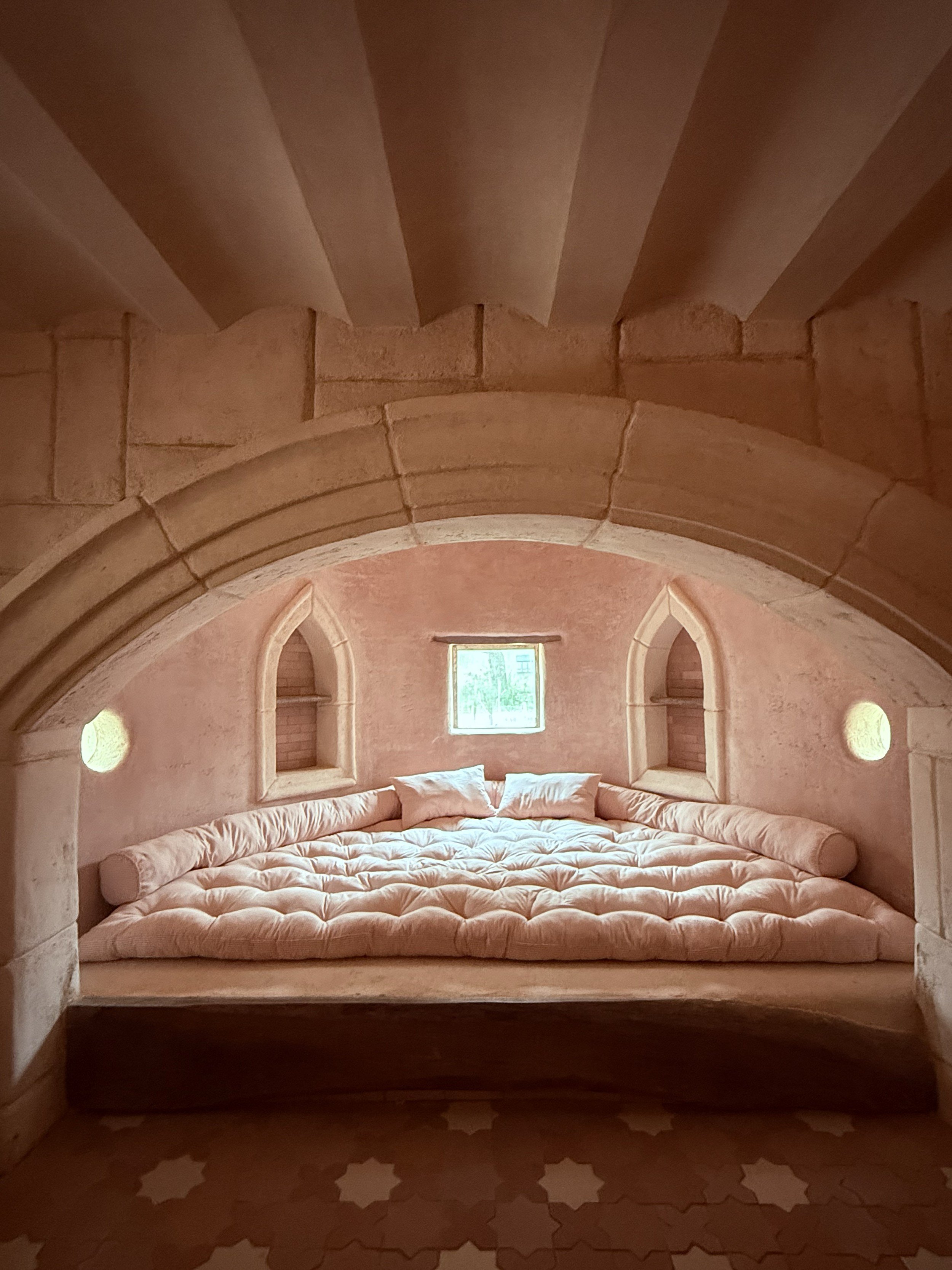 Cozy Pink Plaster Bedroom Alcove with Stone Archway