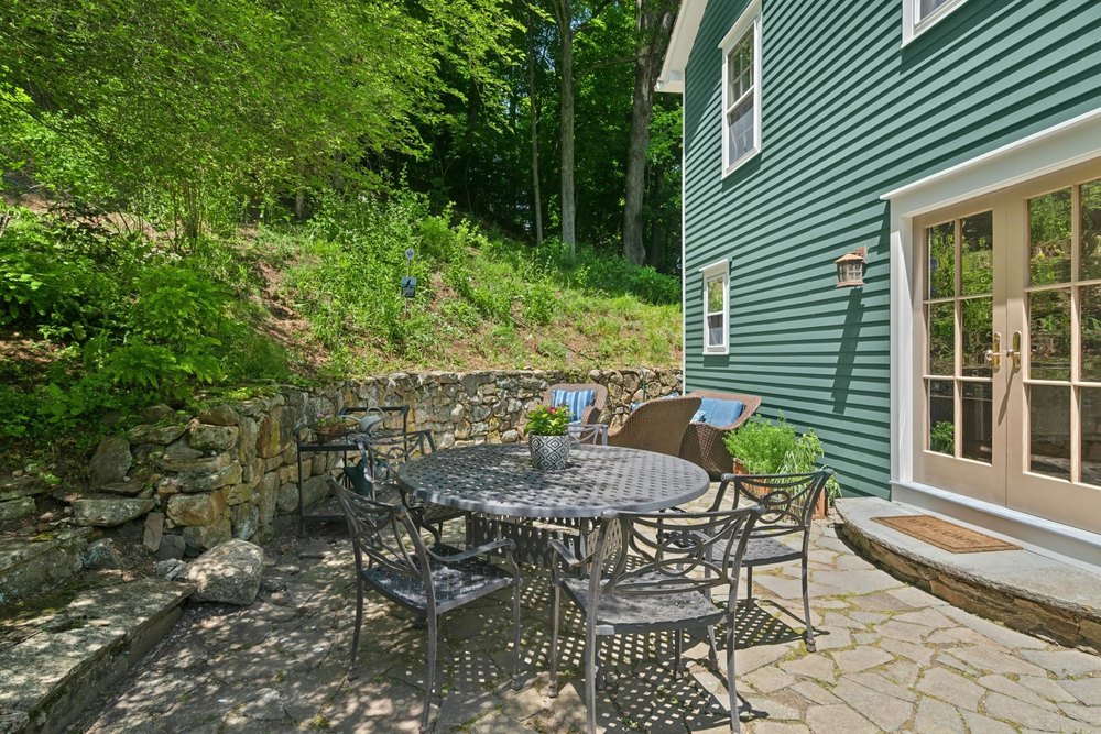 Stone patio overlooking the Certified National Wildlife Habitat in Wilton, CT, on sale for $865,000
