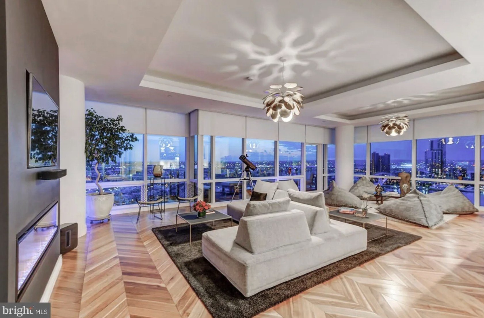 A living room with a white couch and a view from a Baltimore condo