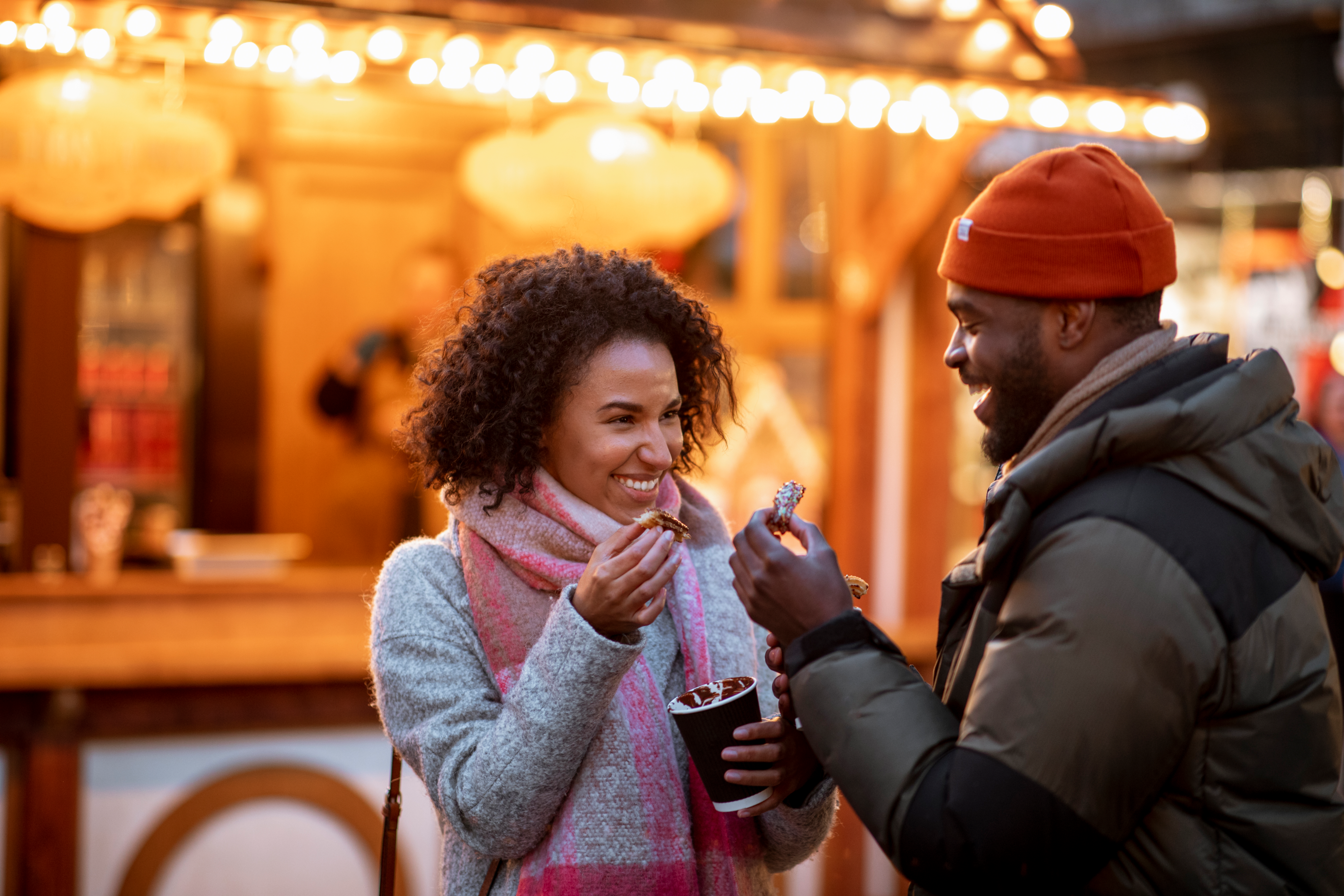 Friends smiling as they eat churros cooked freshly at a food truck