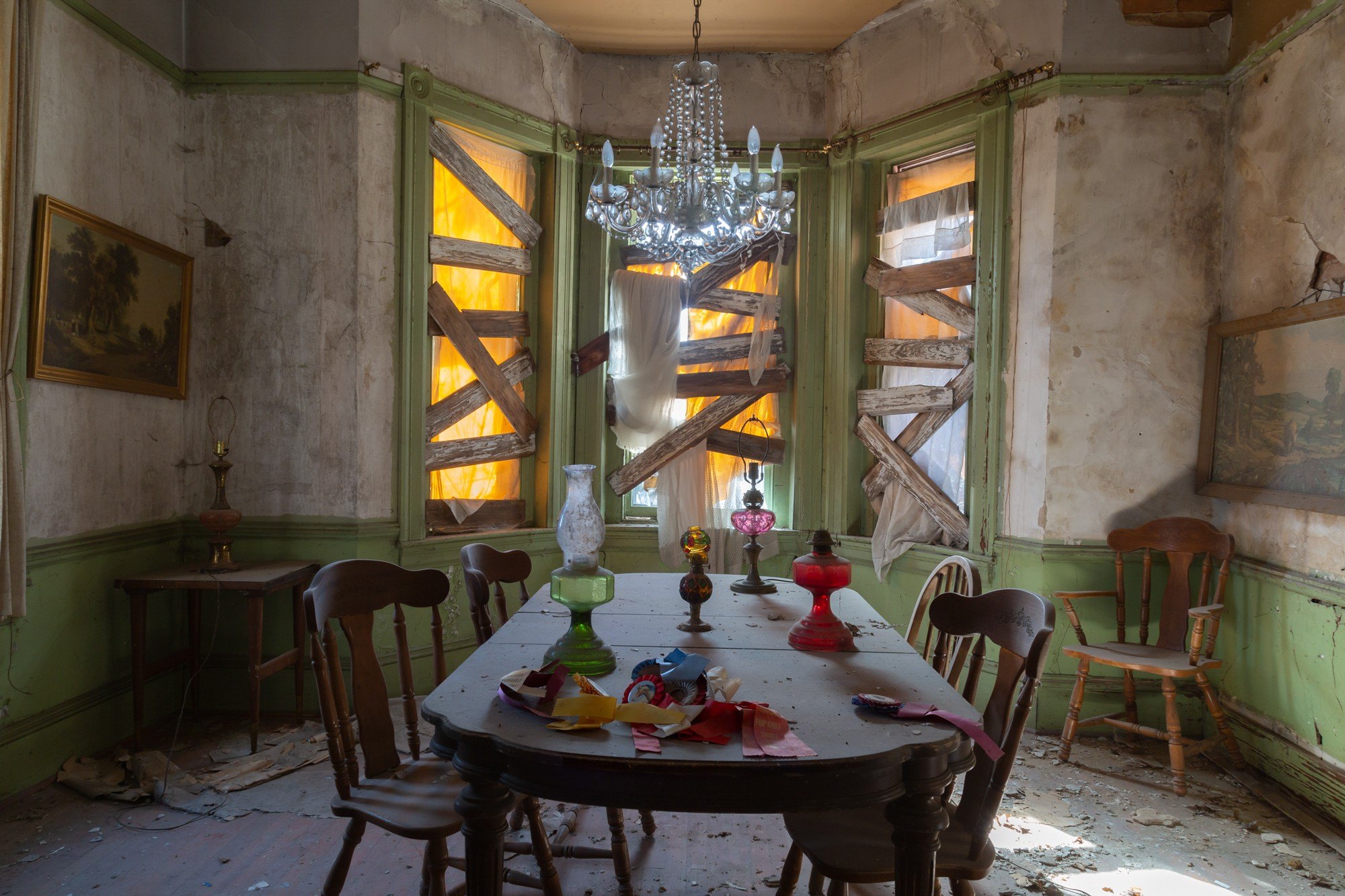 I haunted house on a horse farm with boarded up windows and a chandelier