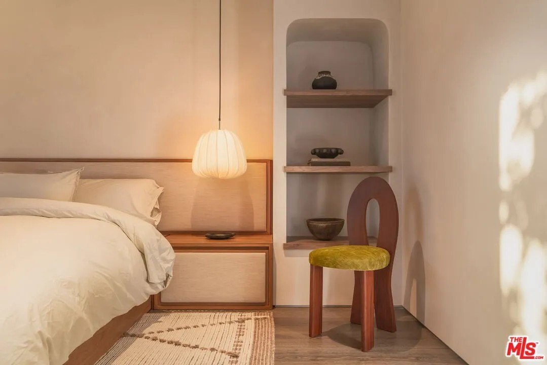 Built in shelving with an artistic chair in front in a luxury home in Malibu owned by Gal Gadot