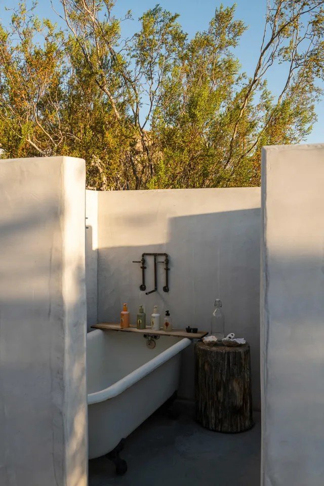A unique outdoor bath room contains an al fresco but private bath and shower.