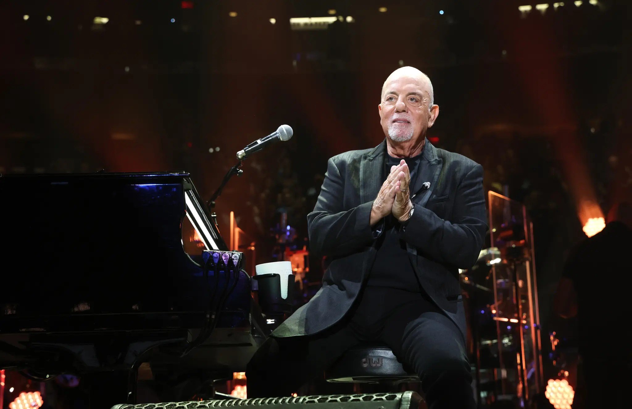 Billy Joel on stage at the piano looking grateful