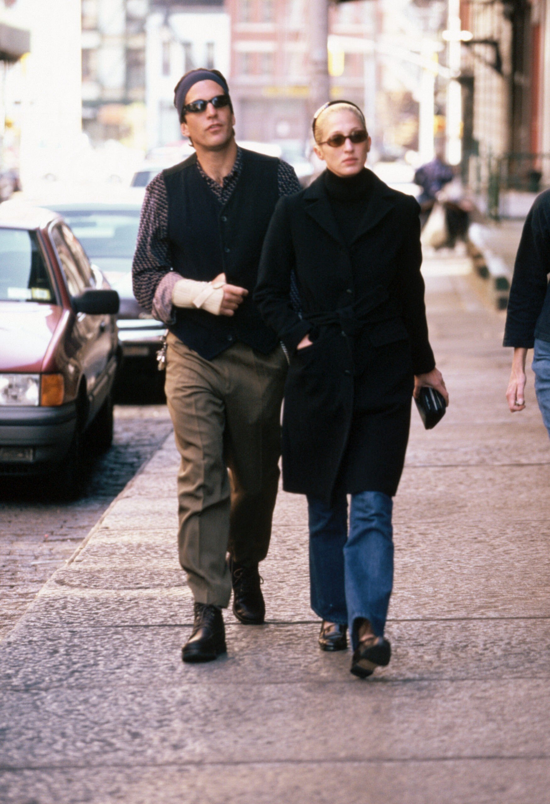 John F. Kennedy Jr. walks along a New York City street with wife Carolyn Bessette.