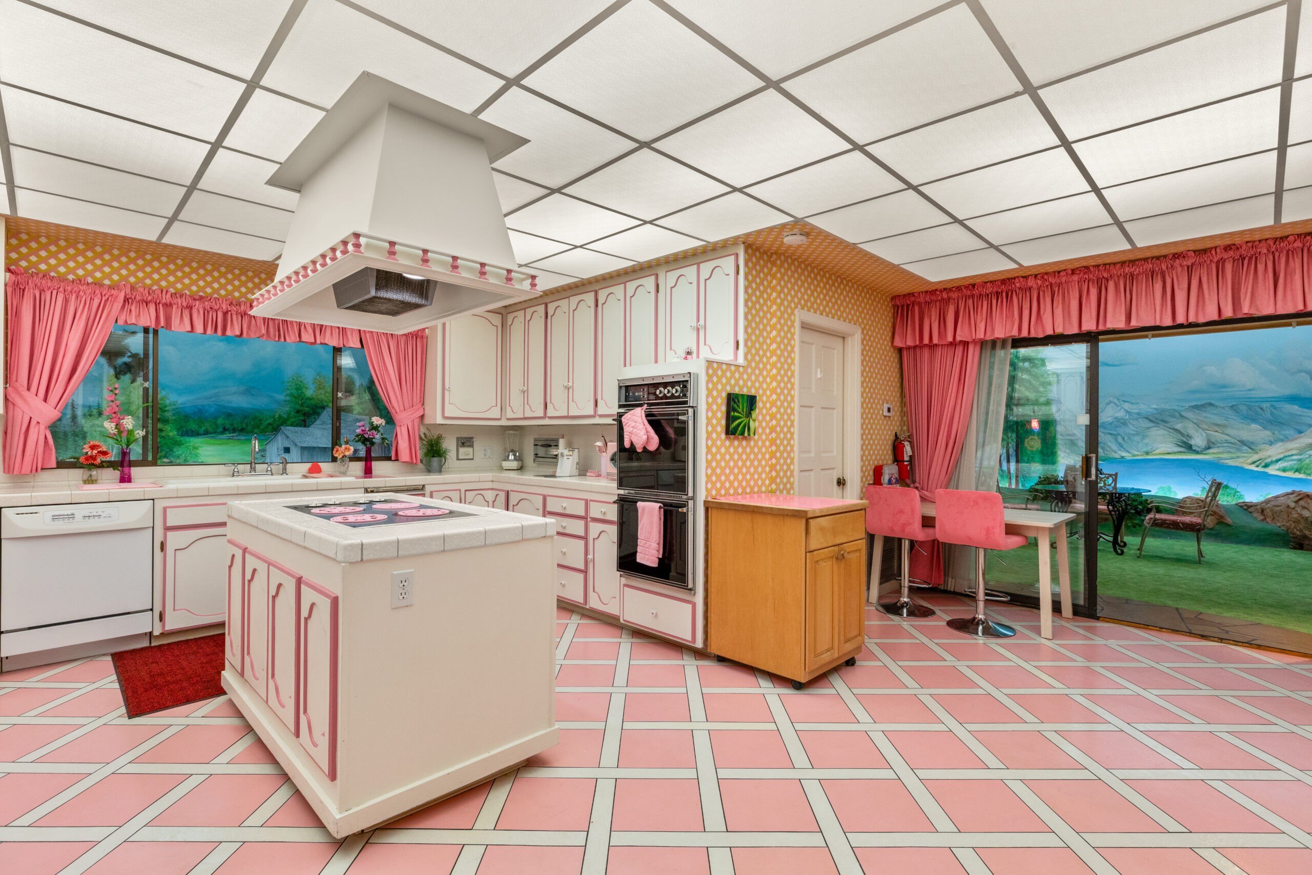Kitchen in an underground bunker with windows to painted backyard scenes. Credit: Rooted Elements Media 