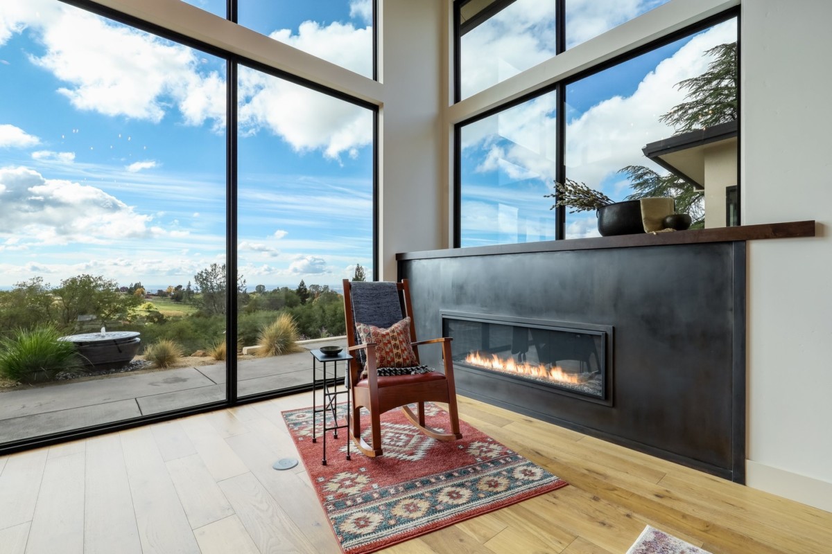 fireplace with rocking chair and patterned rug