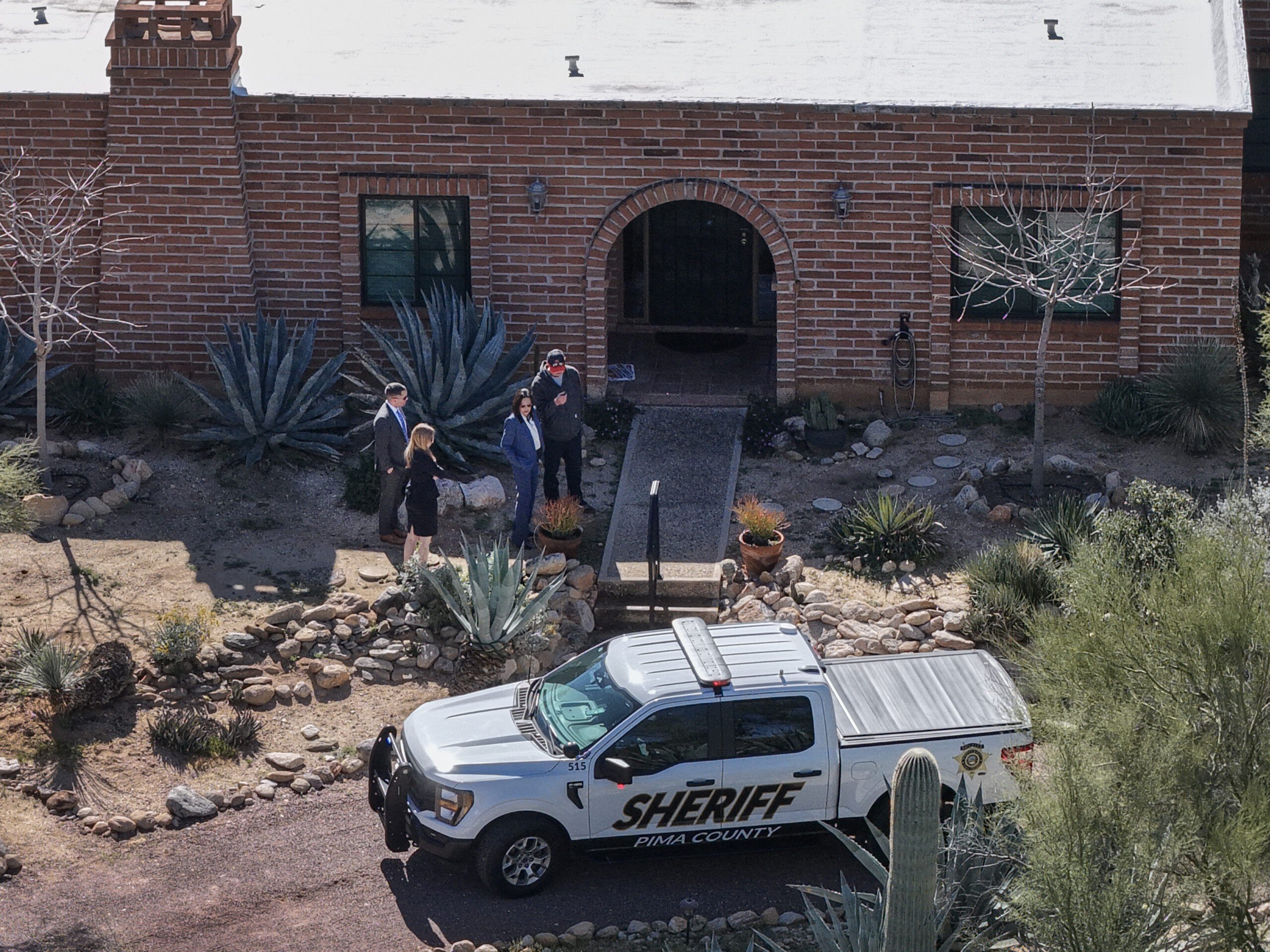 In an aerial view, law enforcement officials visit the backyard of Nancy Guthrie's residence