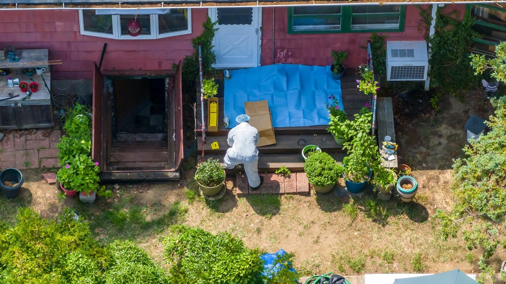 Police Investigator works in the backyard of Gilgo Beach murders suspect Rex Heuermann's home