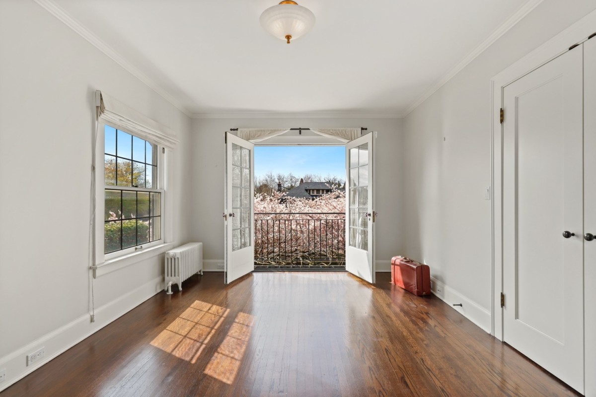 sustainably harvested real wood floors in an empty room with a balcony