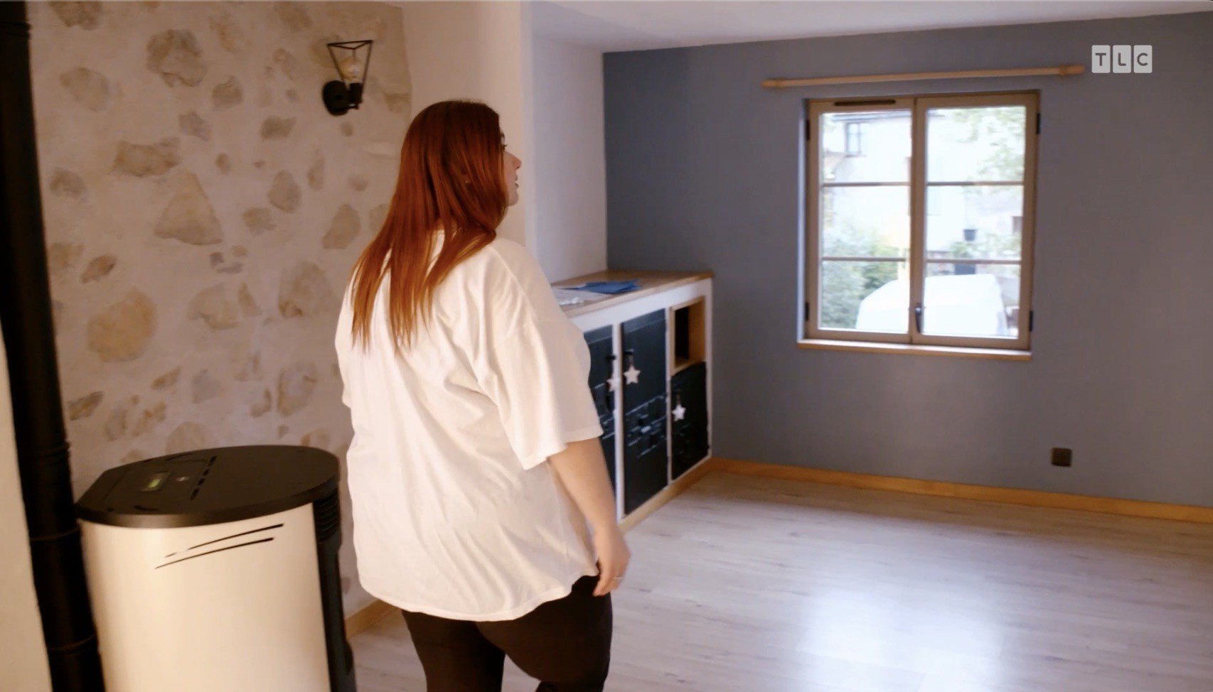 Arches, additional scallop details, and more stonework show up in several rooms, including one with an accent wall painted in a muted blue hue.