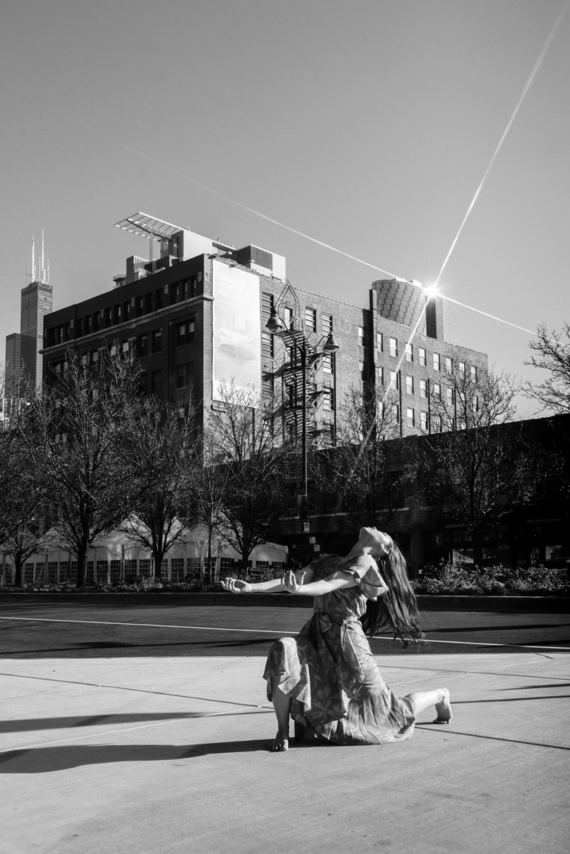 Person dancing in the street with buildings 