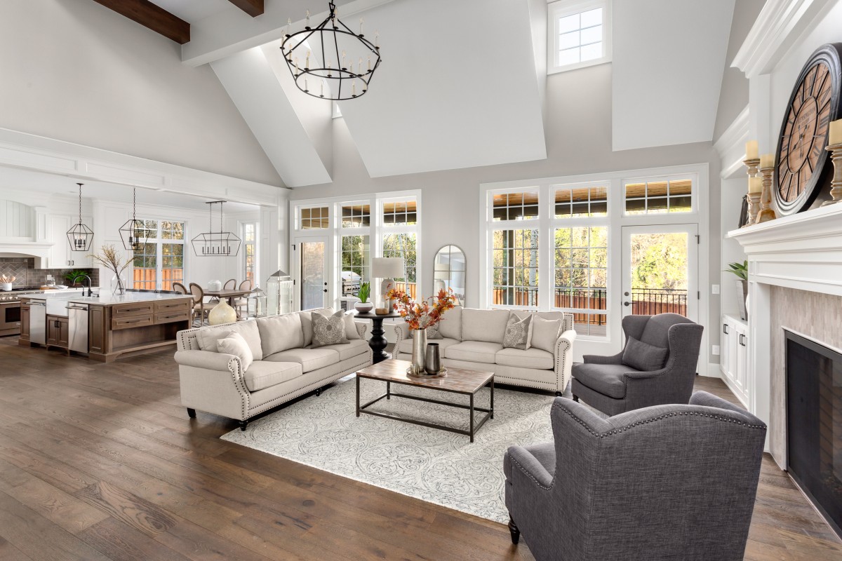 Beautiful living room and kitchen in new traditional style luxury home. Features vaulted ceilings and elegant furnishings.