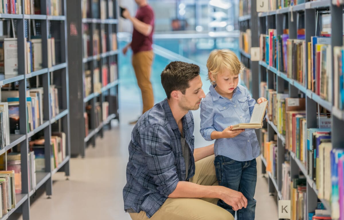 Father and son reading in a public library in Birmingham, AL