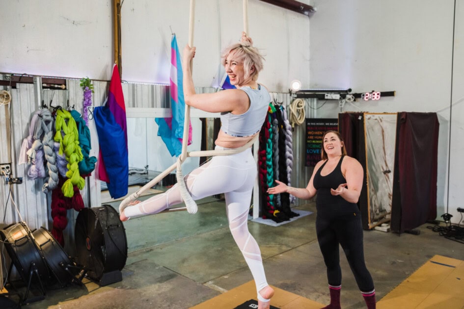 Woman in a class standing on a rope with one foot