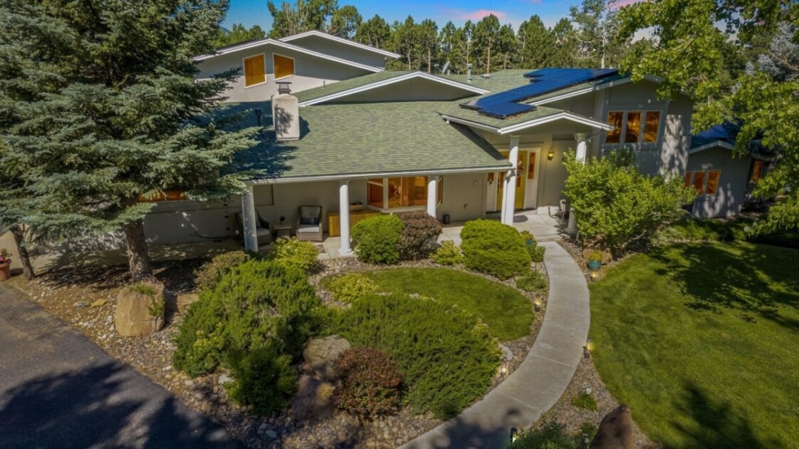 Home with mature trees surrounding it and a long pathway to the front door