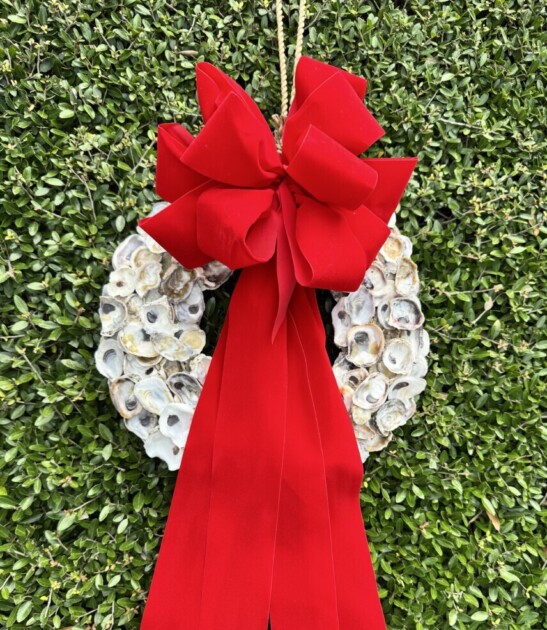 An oyster shell wreath with an oversized red bow