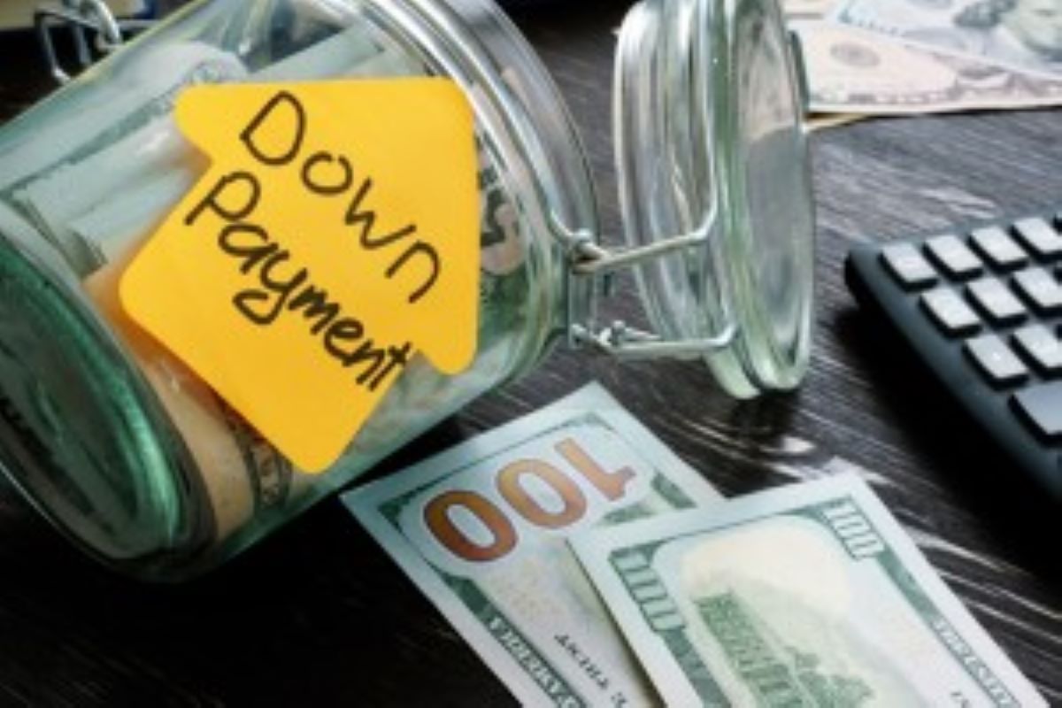 A glass jar labeled down payment containing US dollars intended to be a cash offer on house. 