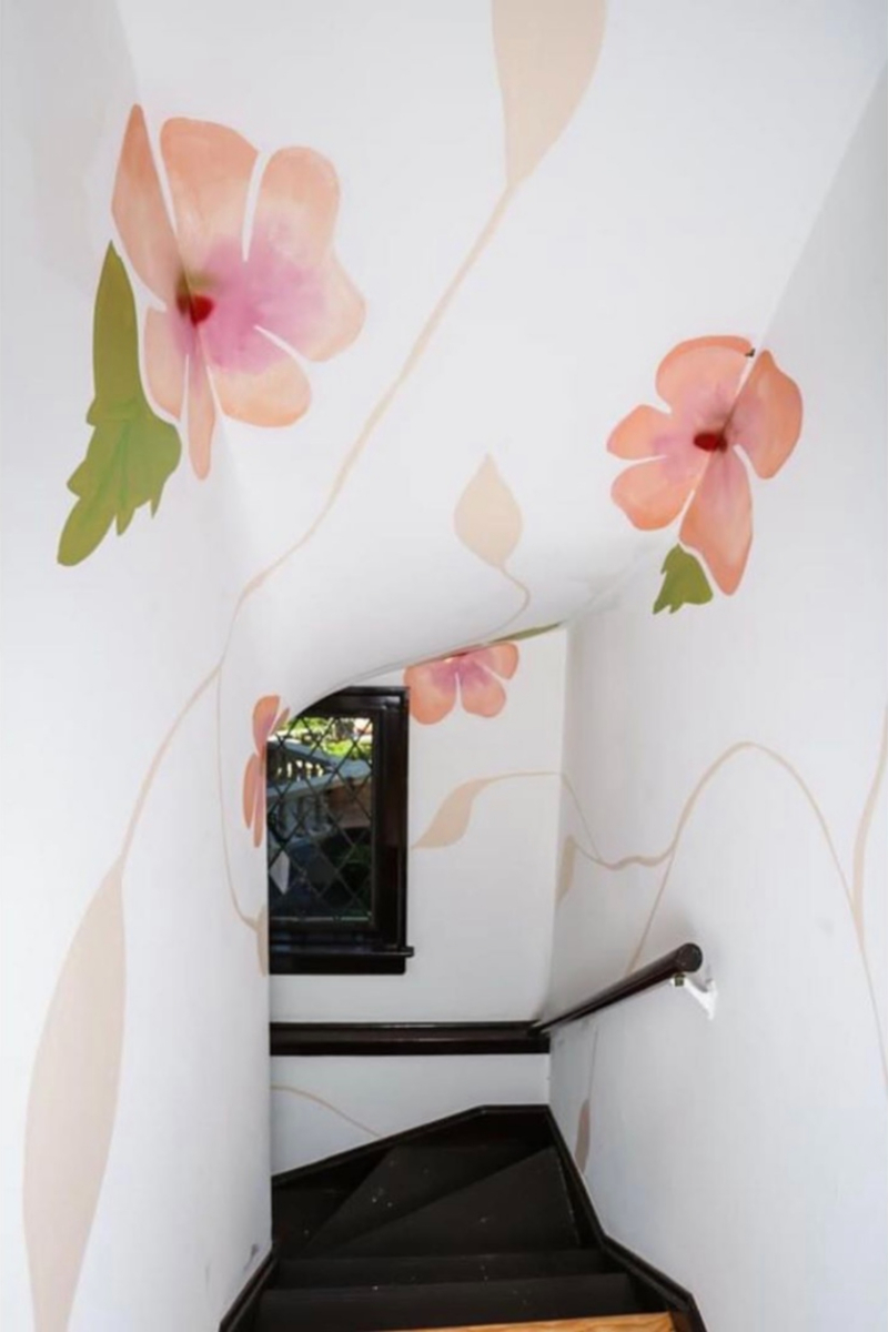 A stairway with a floral mural