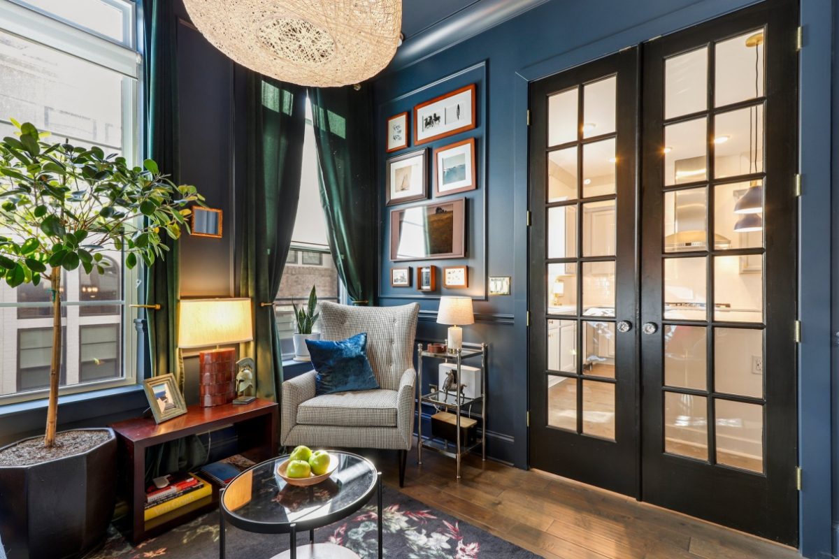 A navy colored home office decorated with pictures and foliage