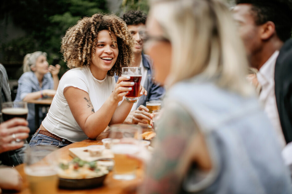 Friends sitting at outdoor restaurant and drinking beer