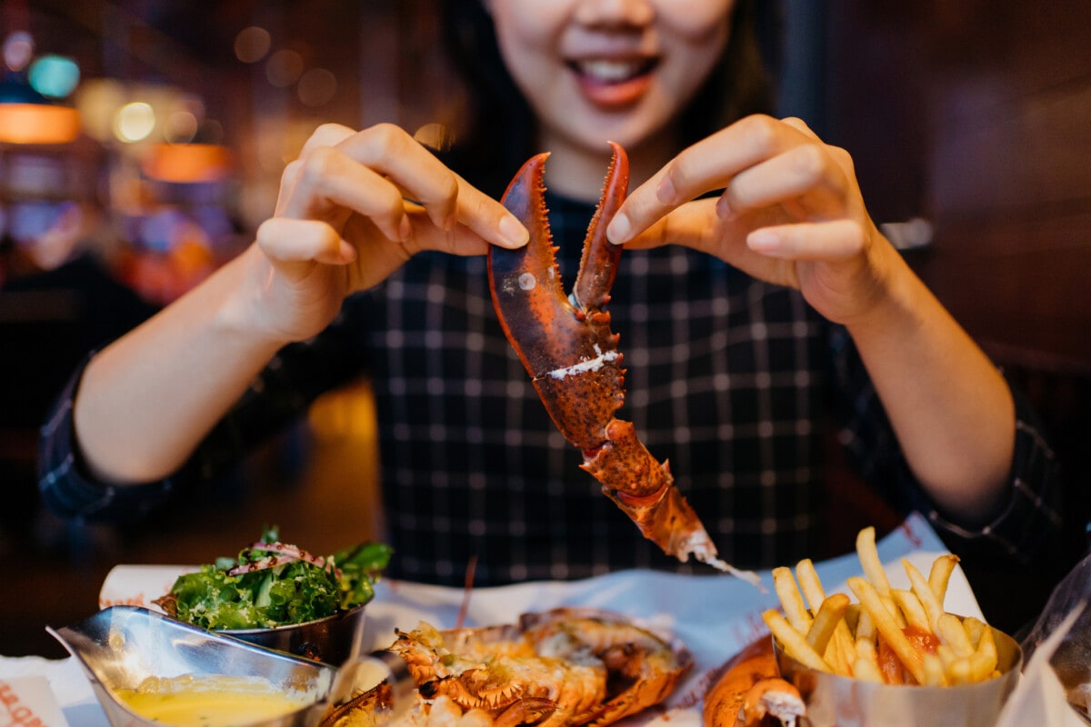 holding a grilled lobster claw in restaurant getty