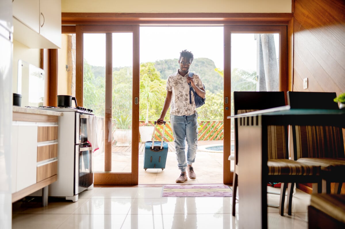 man with suitcase moving into his short term rental booking