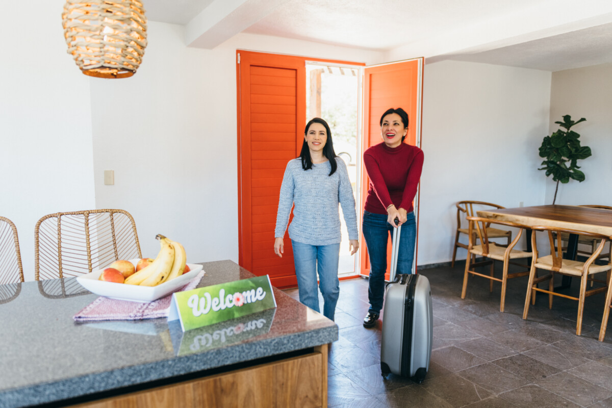 New tenants arriving at vacation rental pushing luggage