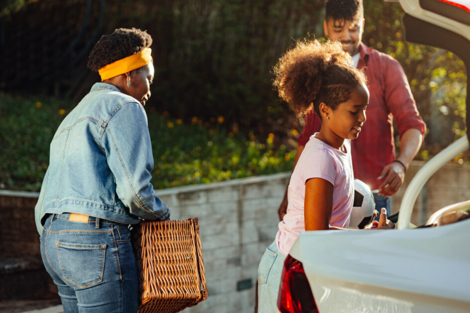 Family packing stuff for vacation into car
