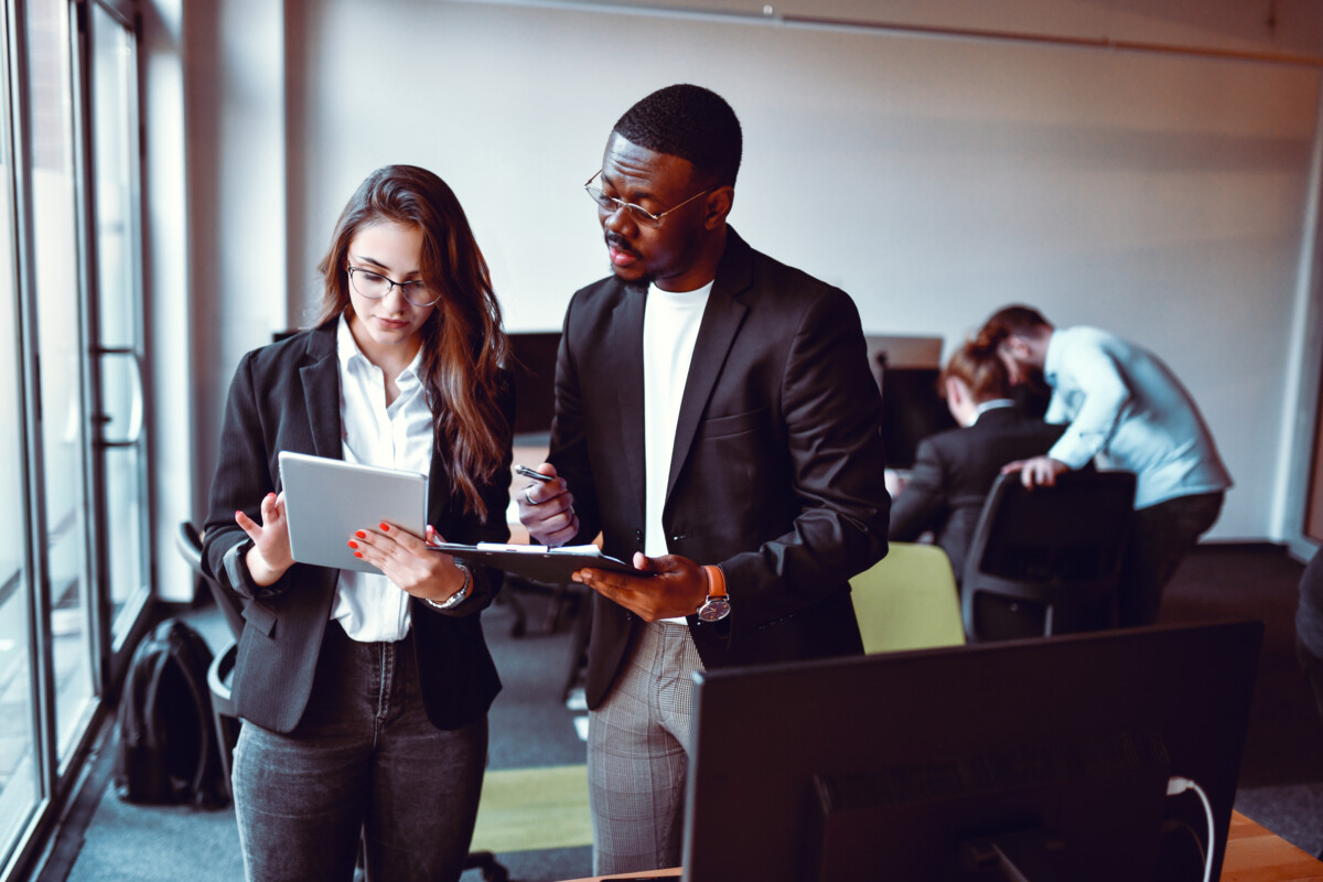 a man and a women employee assessing papers