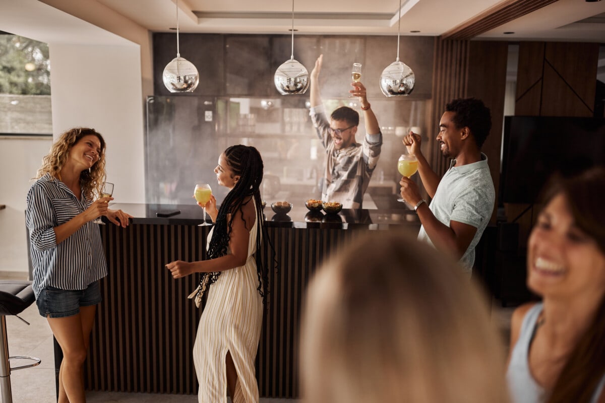 Group of cheerful friends having fun while dancing on a party at home.