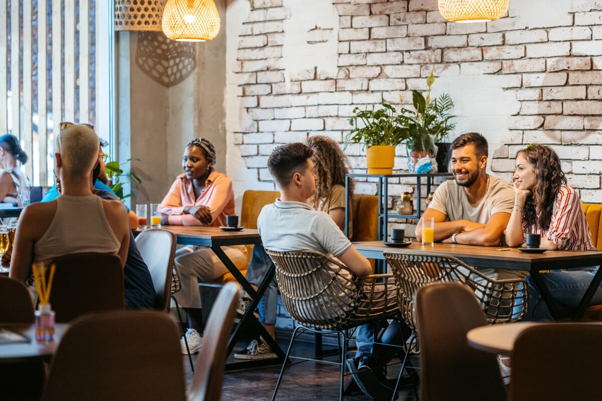 group of friends relaxing in a café, drinking juice and coffee.