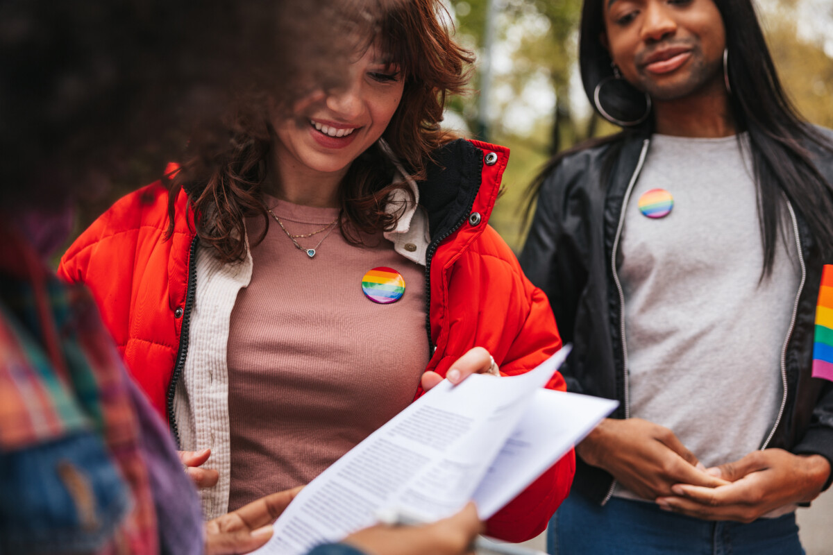 Multicultural group of LGBTQIA+ volunteers in New York City streets approaching people and let them sign up. 