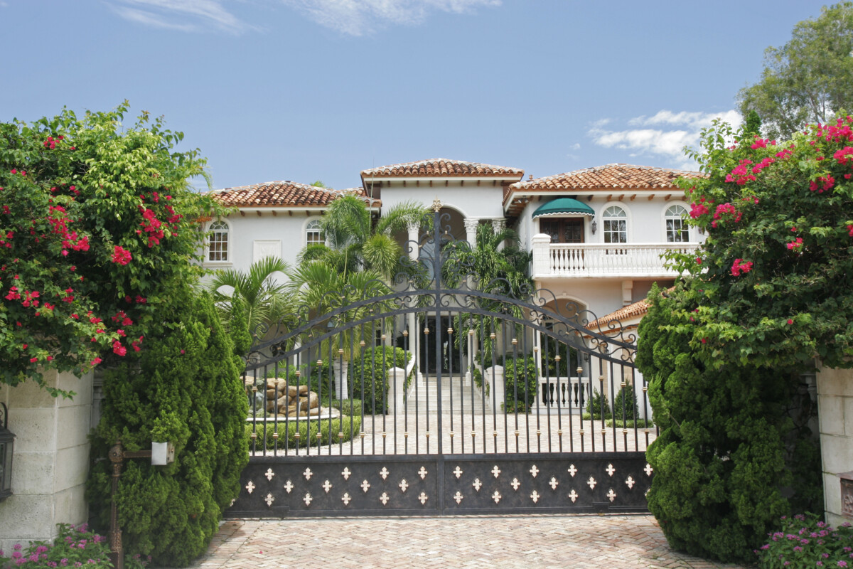 Mansion behind a gate surrounded by tropical greenery _ getty